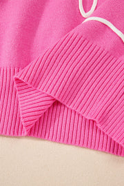 Fuchsia pink knit sweater with ribbed cuffs and a white drawstring detail.