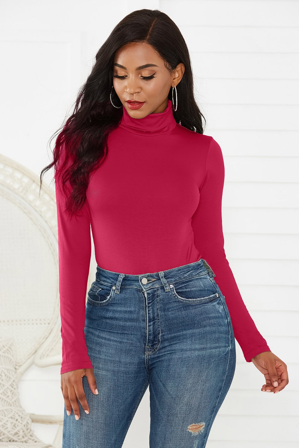 Burgundy turtleneck bodysuit with long sleeves, styled with high-waisted jeans.