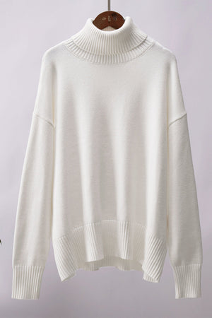 White relaxed roll-neck sweater with a boxy knit and ribbed details.