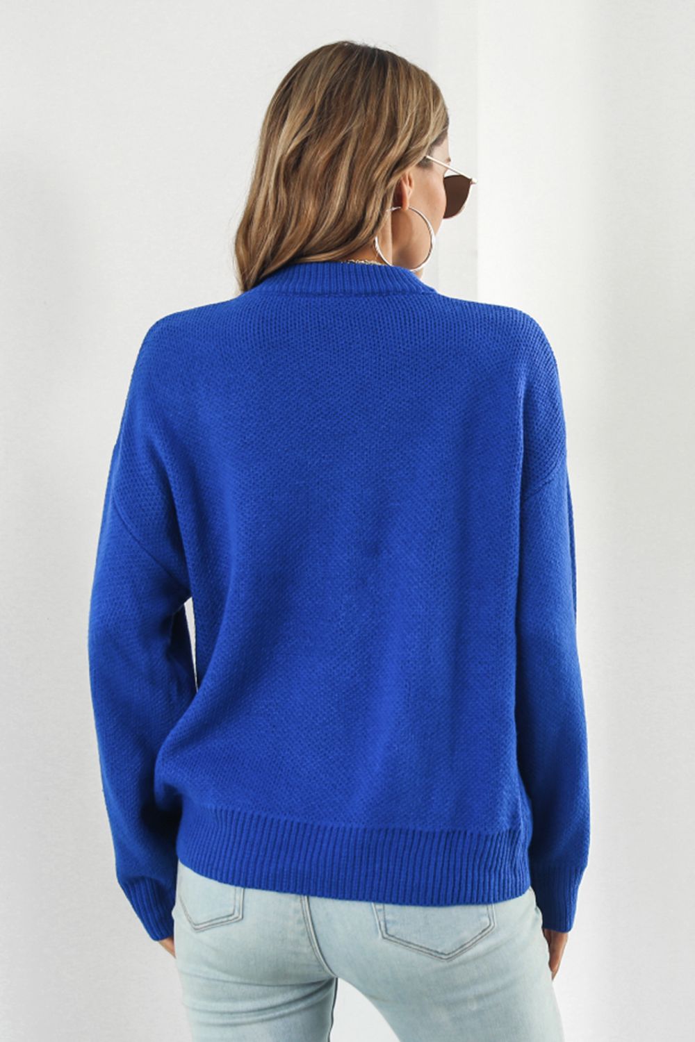Royal blue acrylic sweater with a mock neck and intarsia smiley flower pattern.