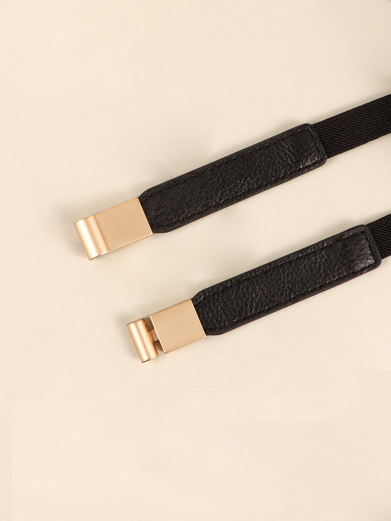 Black elasticated belt with leather detail and gold buckle closure