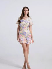 Embroidered floral mini dress in yellow with puff sleeves and a V-neckline.
