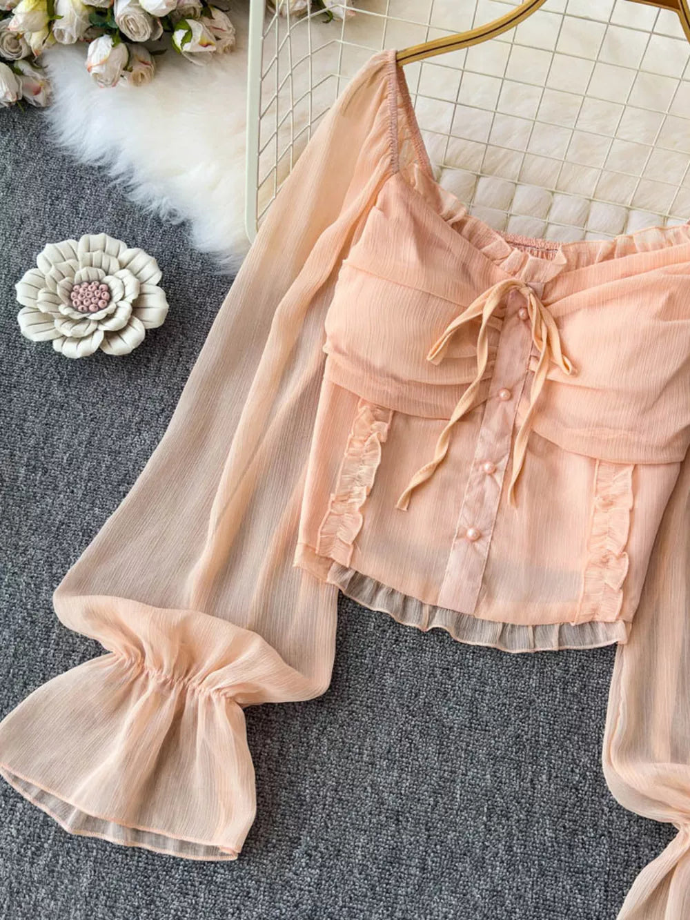 Peach chiffon maternity blouse with ruffled sleeves, bow tie, and button front.