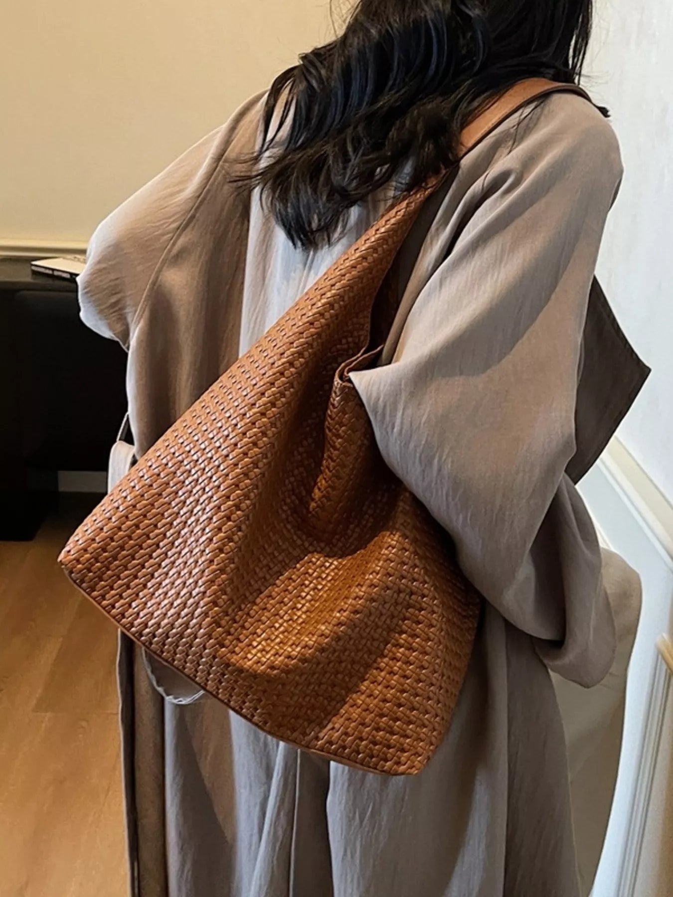 Brown woven straw texture tote bag with leather strap detail.