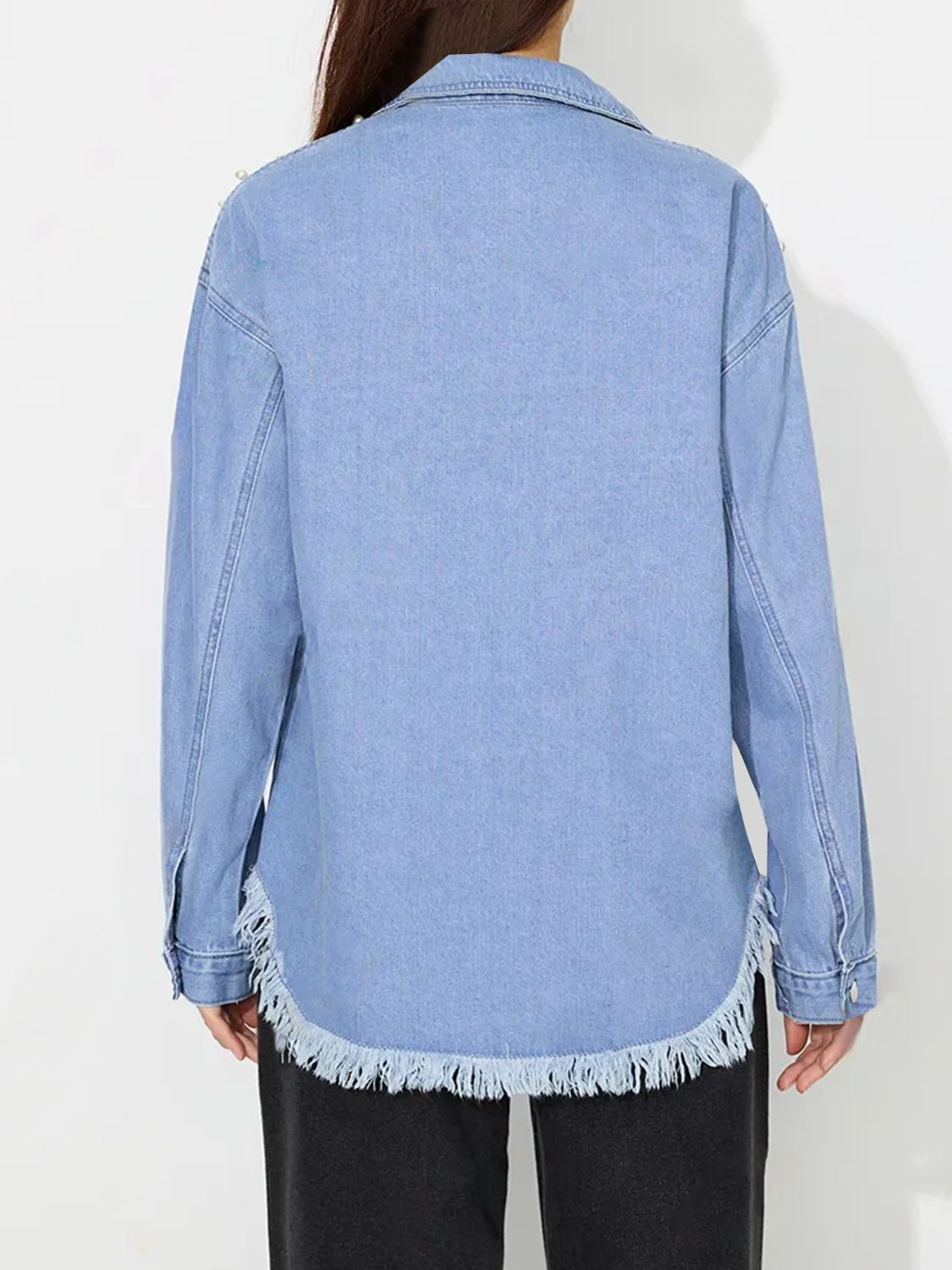 Light wash denim shirt with pearl embellishments and frayed hem.