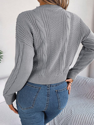 Charcoal cable knit sweater with crew neck and long sleeves.