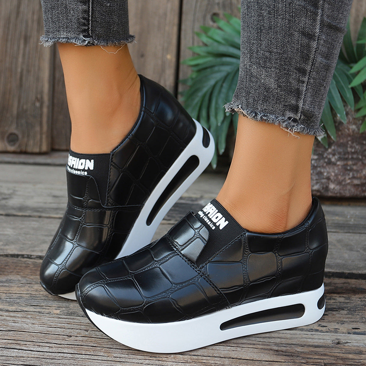 Black crocodile pattern slip-on flats with chunky white platform soles.