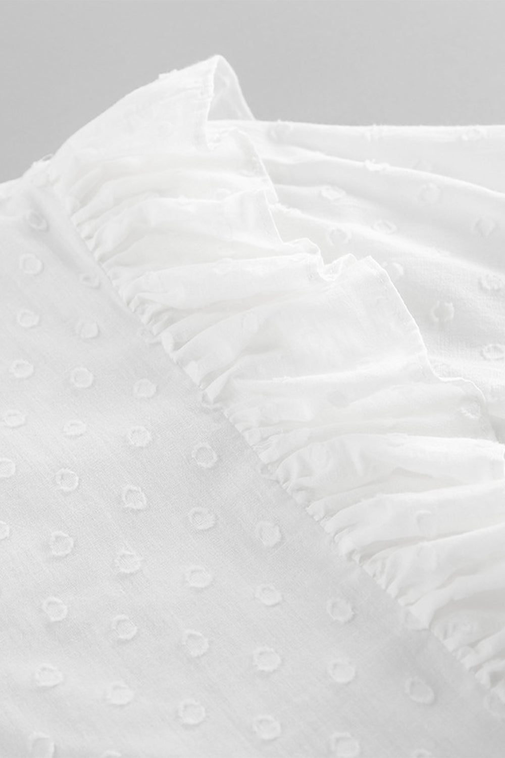 White textured shirt with ruffle trim and dot pattern detail
