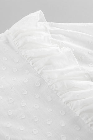 White textured shirt with ruffle trim and dot pattern detail