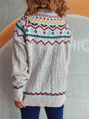 Beige cable knit turtleneck sweater with Fair Isle pattern and speckles.