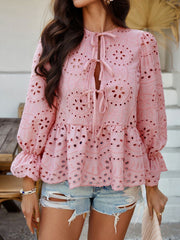 Dusty pink eyelet embroidered peplum blouse with tie neck and ruffled sleeves.