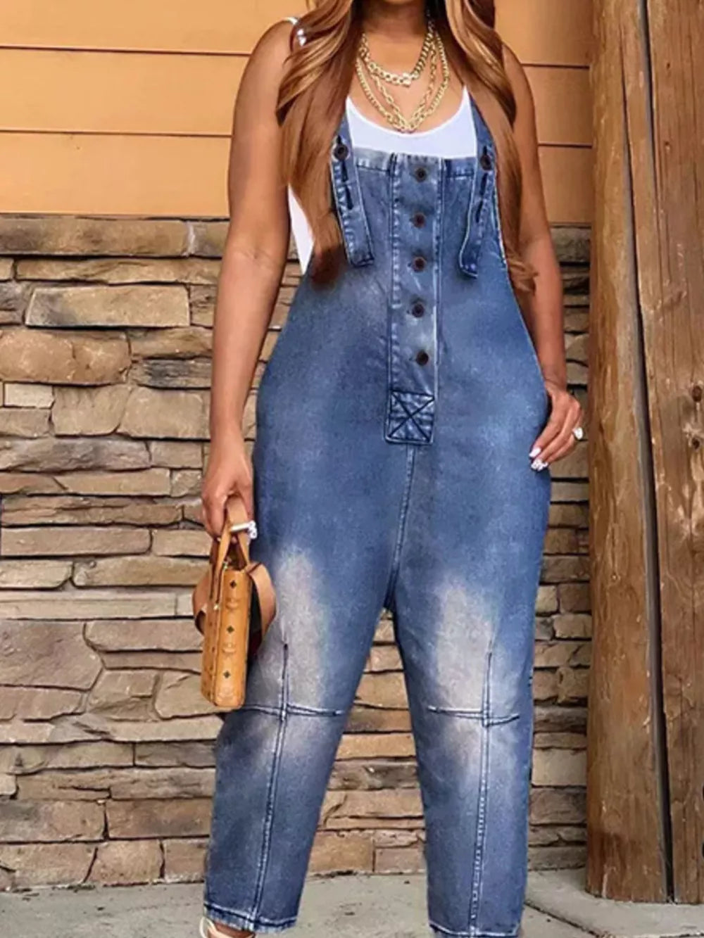Denim overalls with button-front, adjustable straps, and a light blue wash.