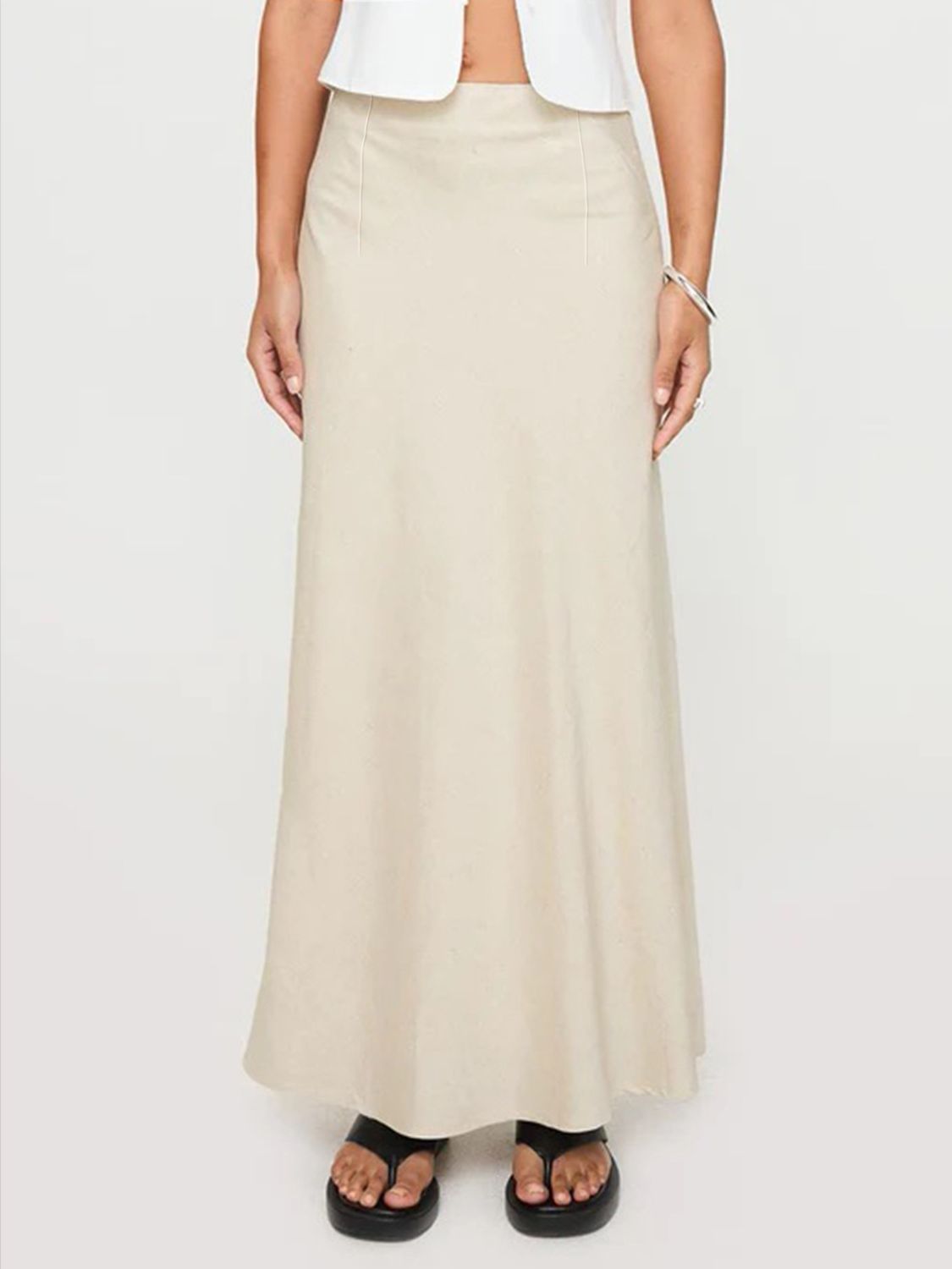 Beige bias-cut maxi skirt with a streamlined silhouette and subtle stitching detail.