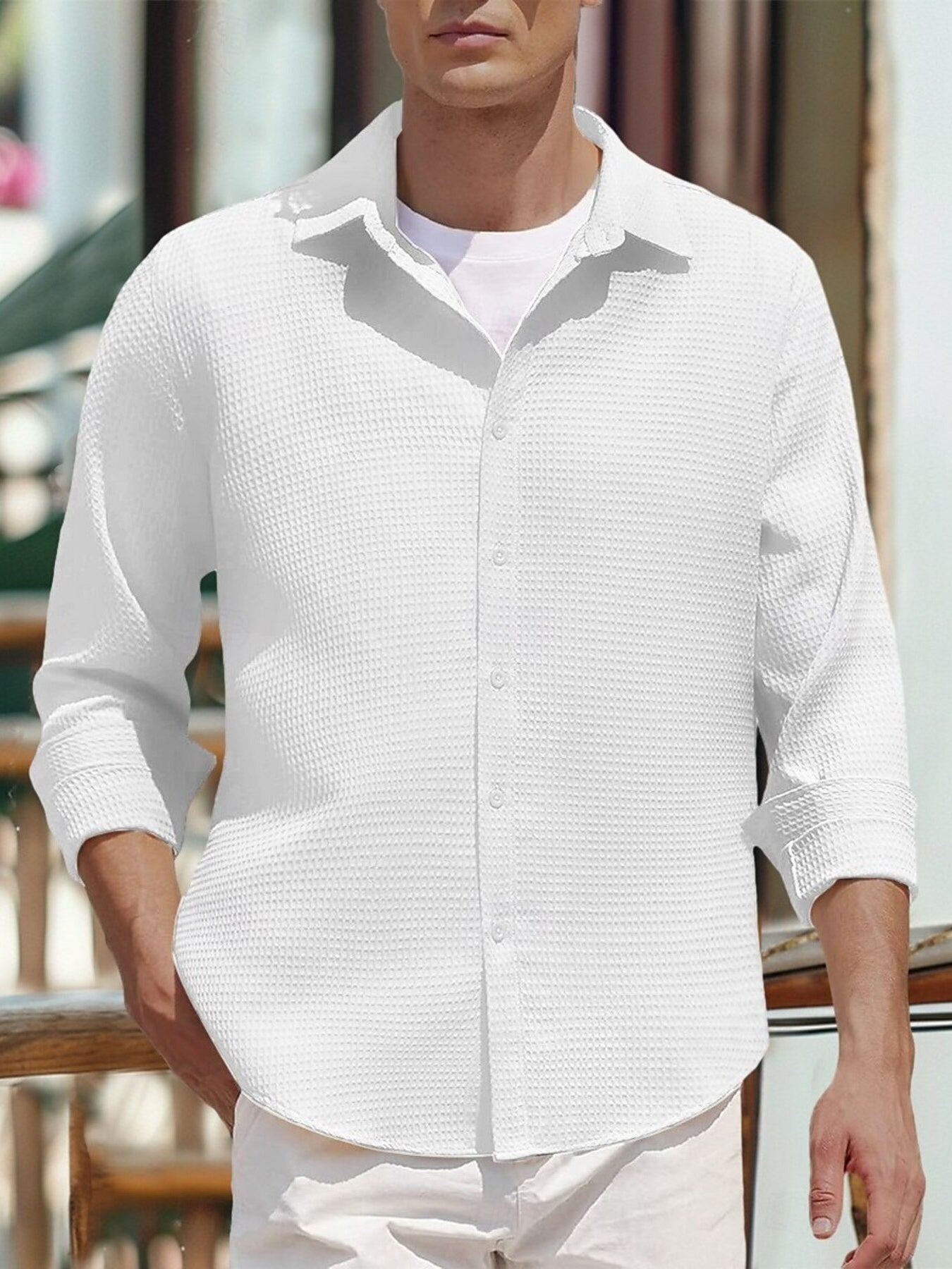 Men's white waffle knit button-up shirt with rolled sleeves, worn over a t-shirt.