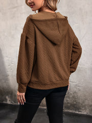 Chestnut cable knit hooded pullover with textured diamond pattern and balloon sleeves.