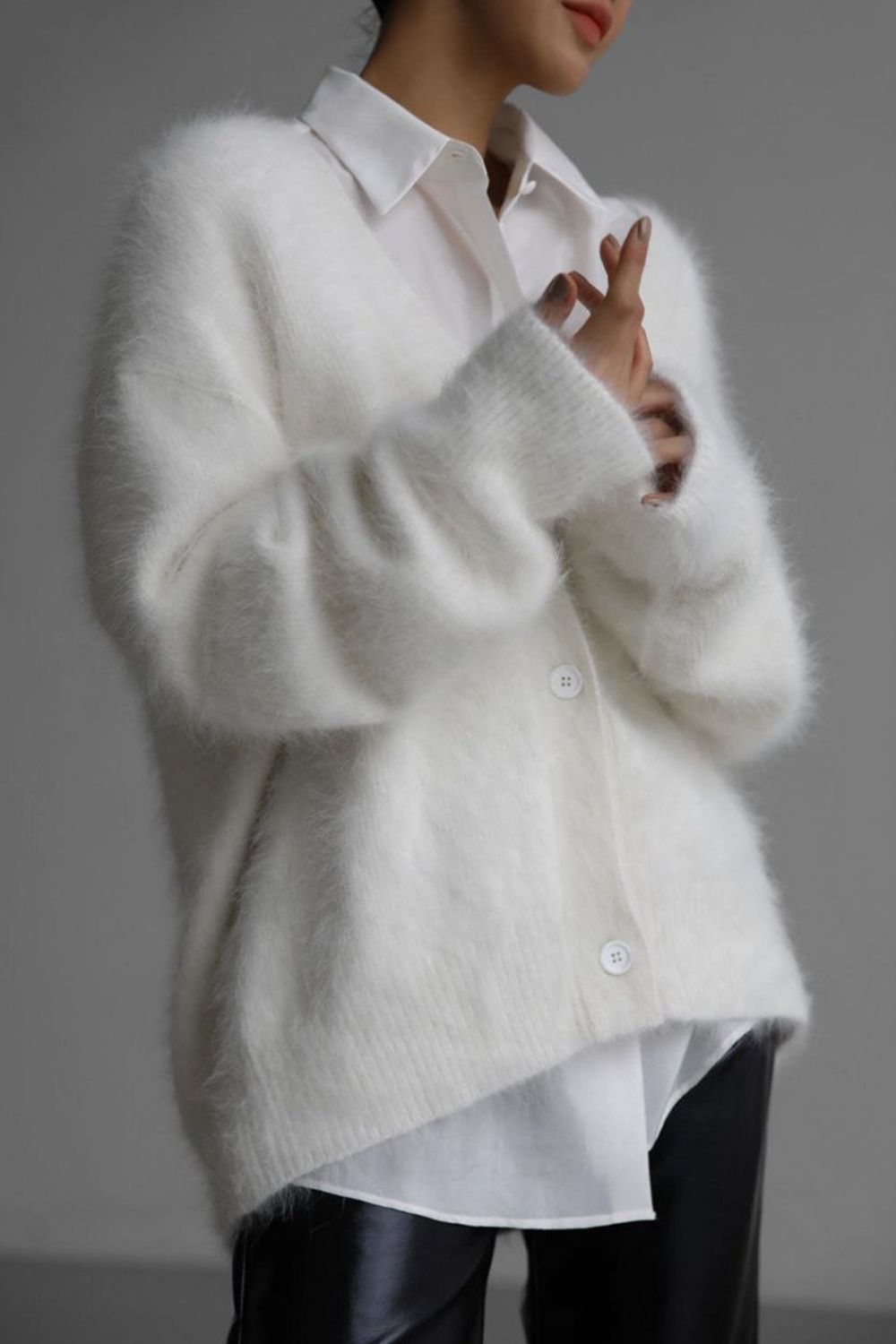 White angora button cardigan with sculpted sleeves, styled over a white collared shirt.