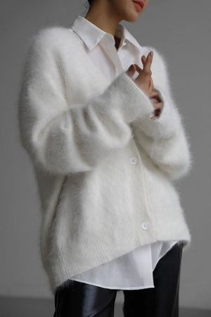 White angora button cardigan with sculpted sleeves, styled over a white collared shirt.