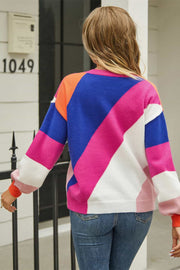 Geometric colorblock knit crewneck sweater with acrylic blend in hot pink, blue, and orange hues.