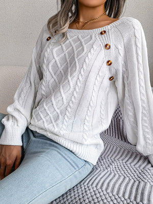 White cable-knit sweater with buttoned shoulder detail and crew neck.