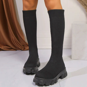Black knit knee-high boots with chunky platform soles and ribbed cuffs.