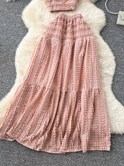Pink ruched polyester crop top and maxi skirt set with tiered frill details.