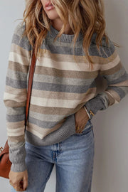 Neutral stripe crewneck knit sweater with ribbed cuffs and hem, styled with jeans.