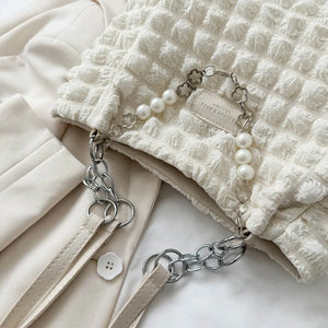 Textured grid pearl chain tote in ivory with silver chain detail and faux pearl accents.