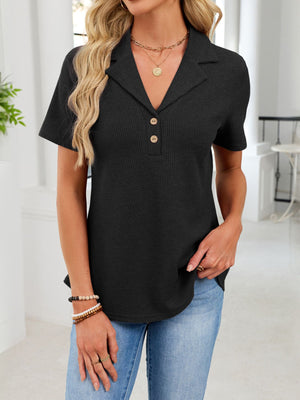 Black waffle knit polo shirt with button placket and collared neckline.