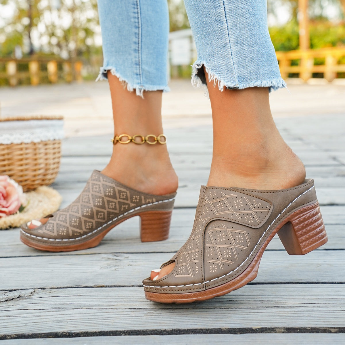 Tan peep-toe block heel mules with laser-cut diamond pattern and white stitching.
