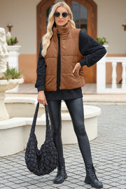 Brown corduroy padded funnel neck vest with zipper front and pockets.