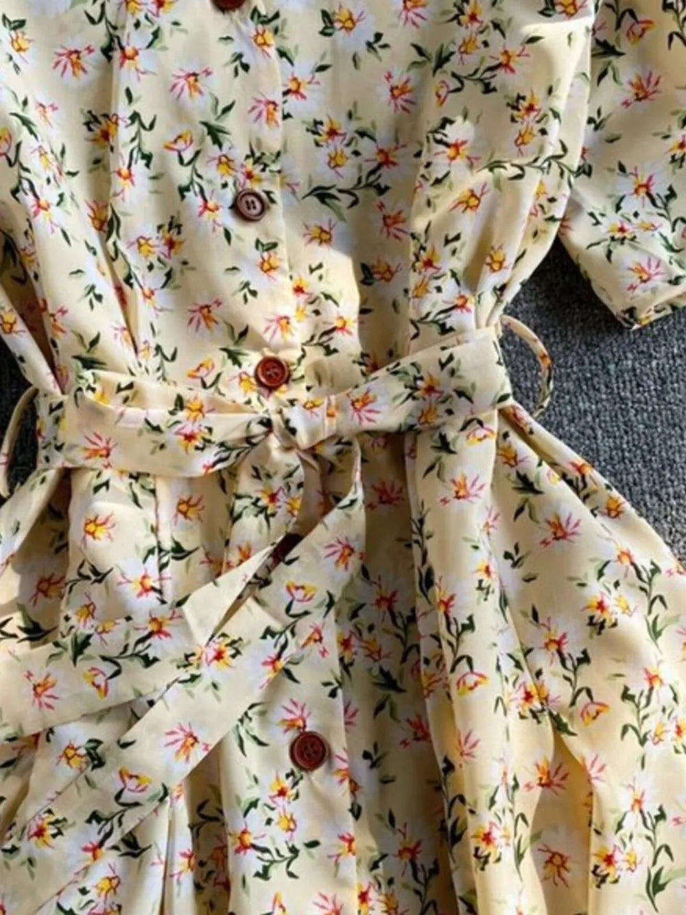 Apricot floral v-neck midi dress with button-down front and belted waist.