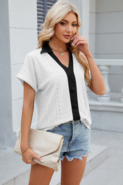 White perforated polo top with black trim and short sleeves.