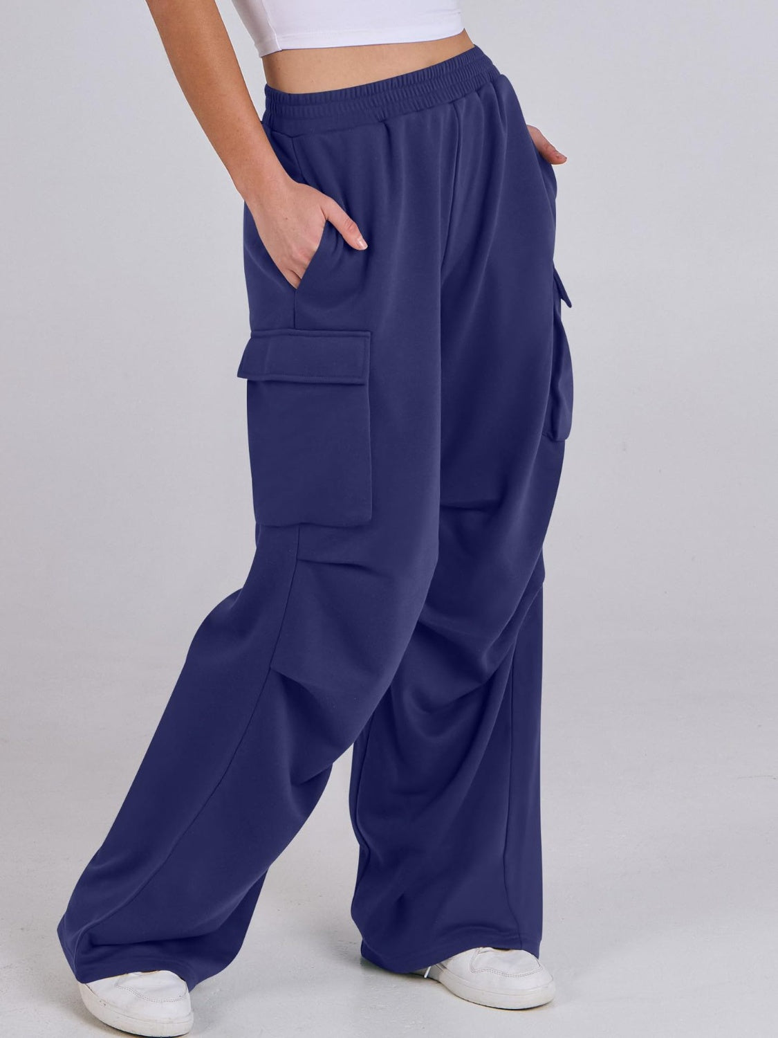 Royal blue sweatpants with cargo pockets and a wide leg, shown on a model.