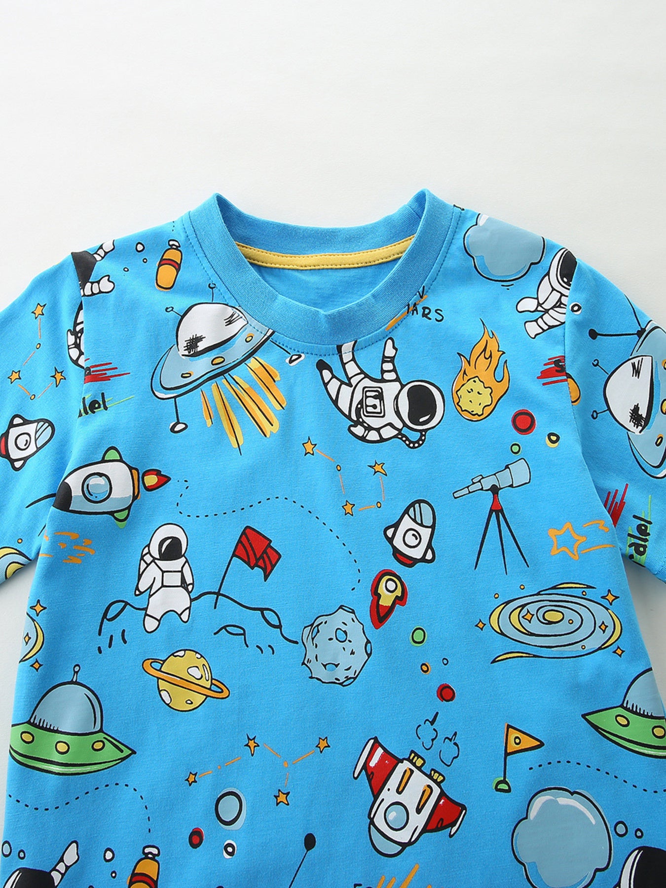 Blue cotton baby t-shirt with playful astronaut and space graphics.
