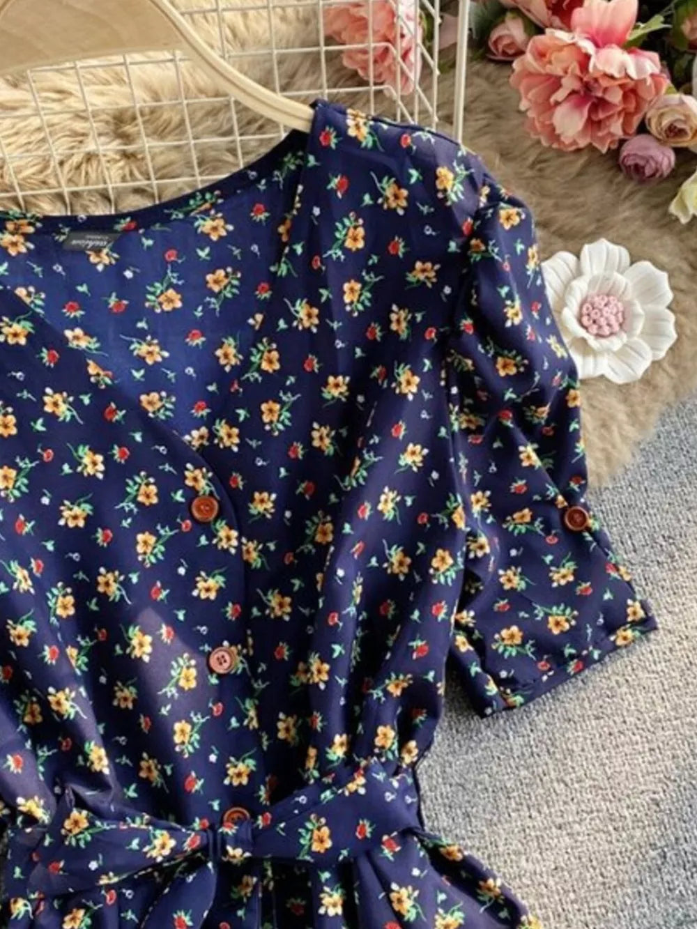 Dark blue floral V-neck midi dress with button front and belted waist.
