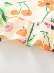Baby t-shirt with whimsical floral and fruit print, ruffled hem, cotton fabric.