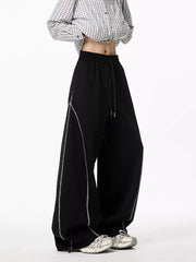 Black wide-leg drawstring sweatpants with contrast stitching detail.