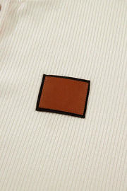 Cream ribbed knit maternity shirt with brown faux leather accent patch.
