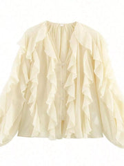Sheer beige long-sleeve blouse with cascading ruffles and button front.