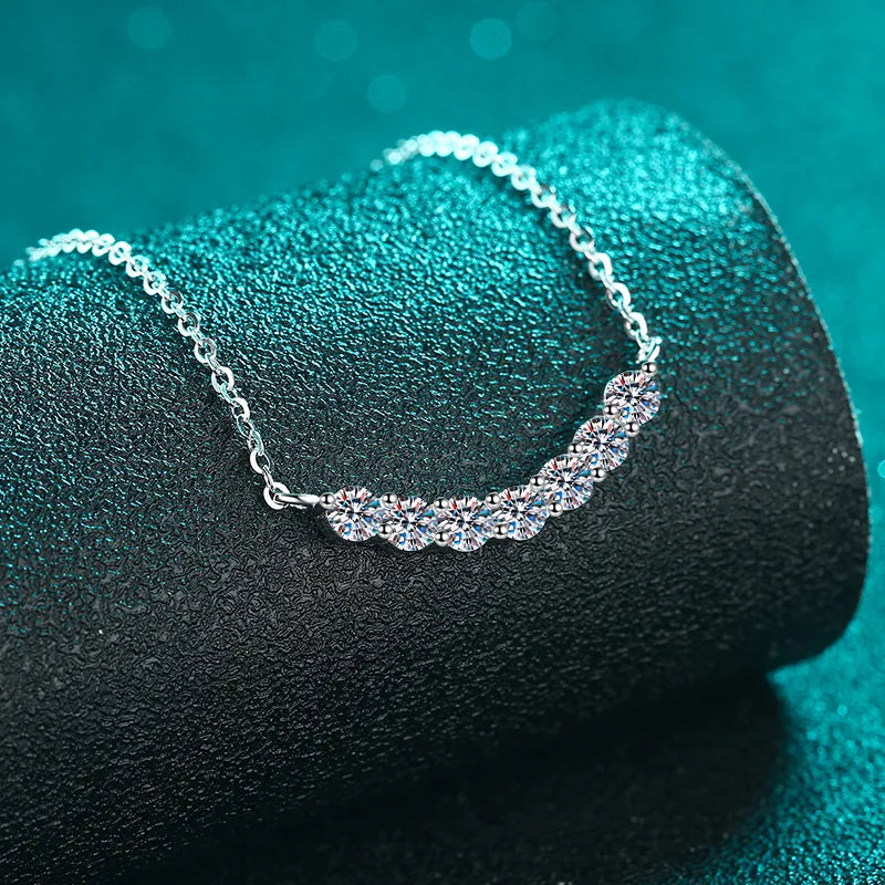 Silver moissanite necklace with a curved row of sparkling stones.