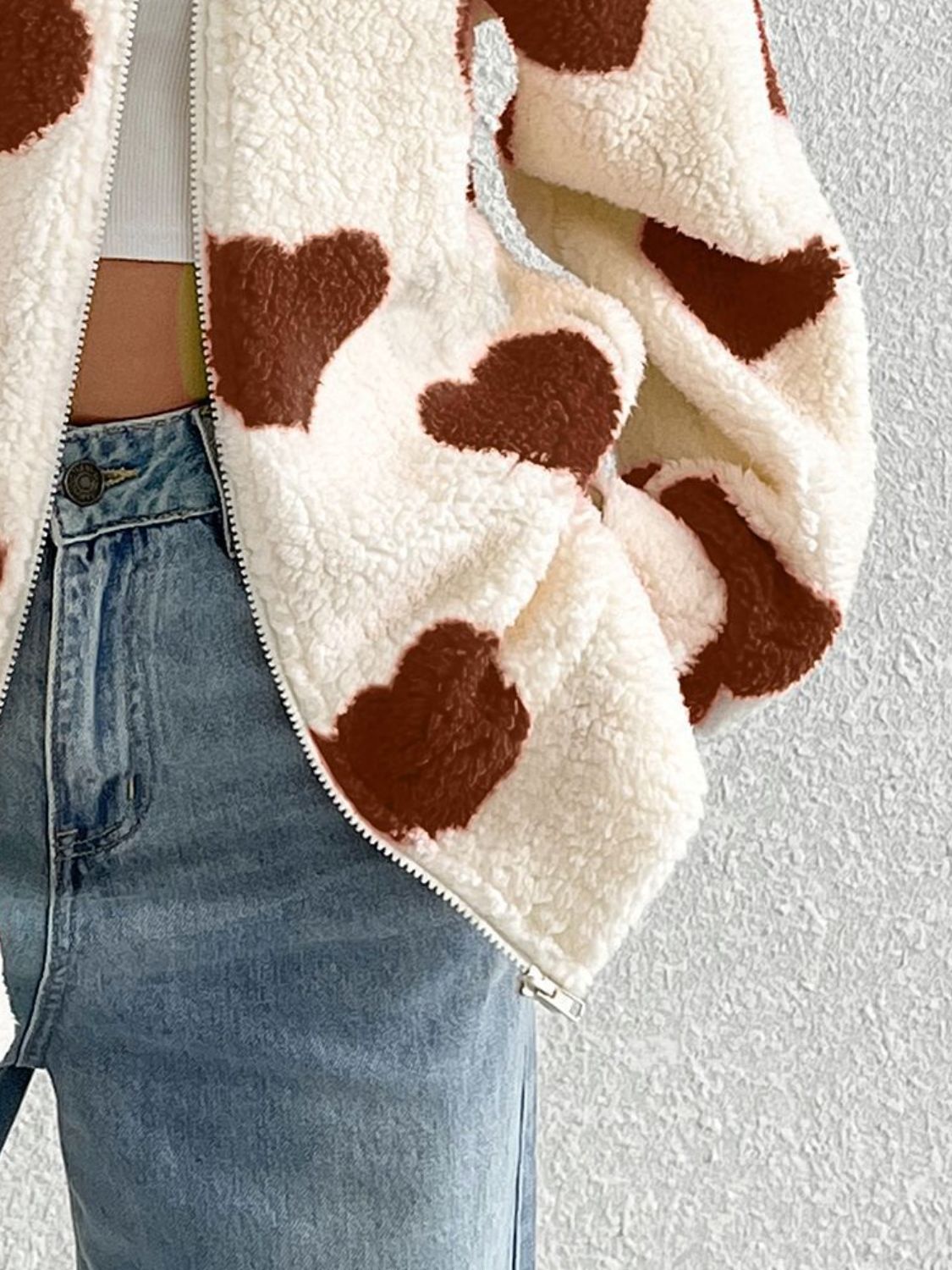 Heart print sherpa zip-up jacket in brown and white, with a fuzzy texture.