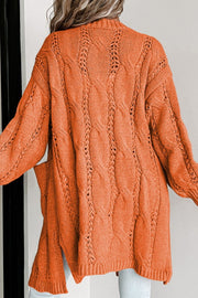 Burnt Coral cable knit open-front cardigan with pockets and openwork details.