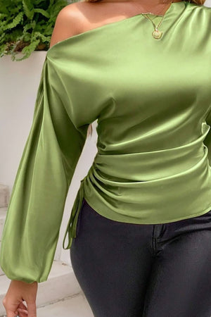 Matcha green satin blouse with asymmetric neckline, ruched side detail, and balloon sleeves.