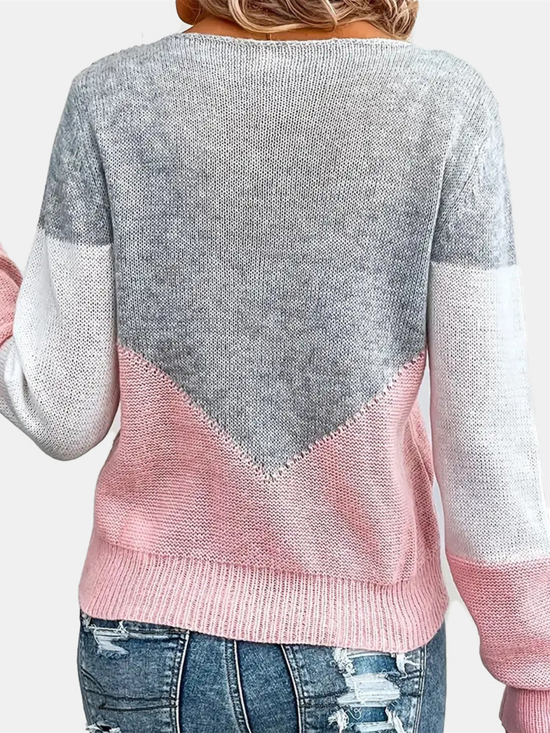 Colorblock knit sweater in pink and gray with a V-shaped yoke detail.