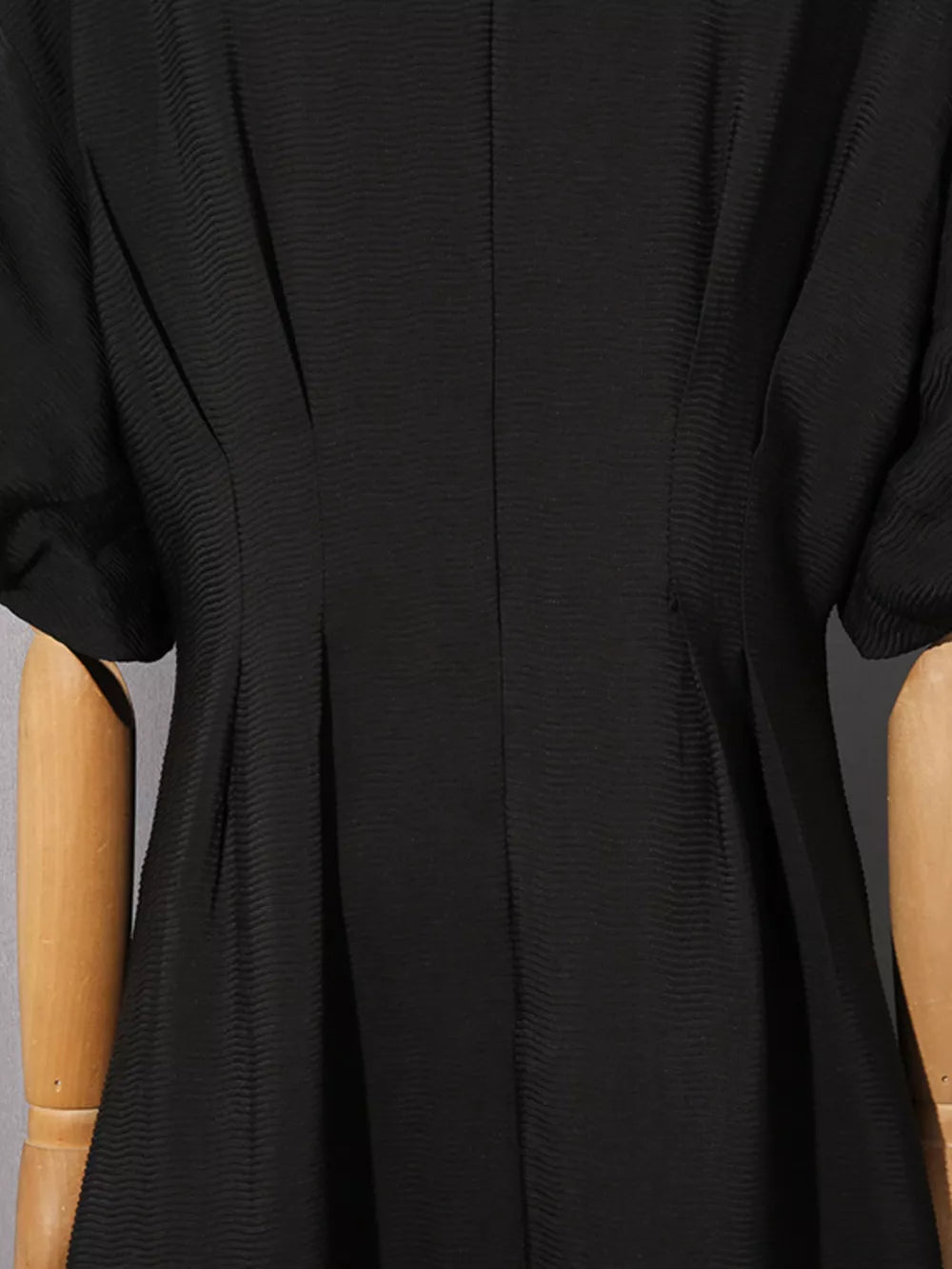 Black midi dress with puff sleeves and textured fabric.