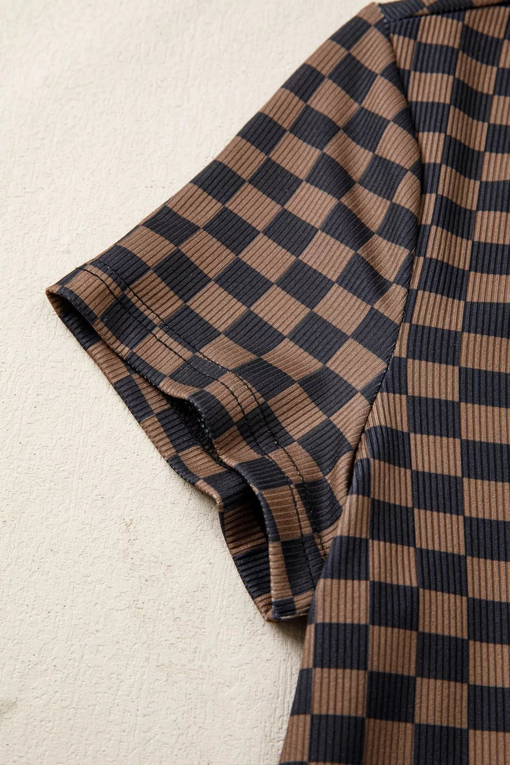 Checkerboard patterned dark brown ribbed t-shirt with short sleeves and round neck.