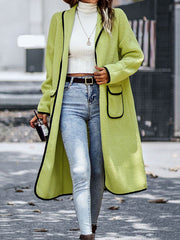 Lime teddy coat with contrast trim detailing and pocket, worn open over a white turtleneck and jeans.