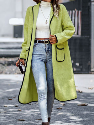 Lime teddy coat with contrast trim detailing and pocket, worn open over a white turtleneck and jeans.