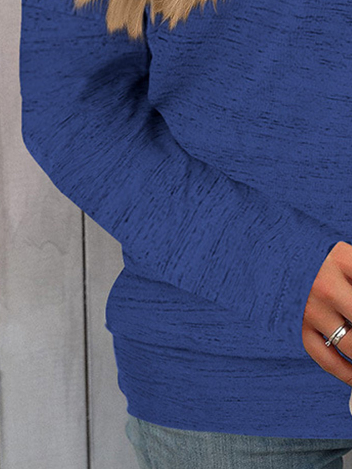 Off-the-shoulder royal blue heathered knit sweater with long sleeves.
