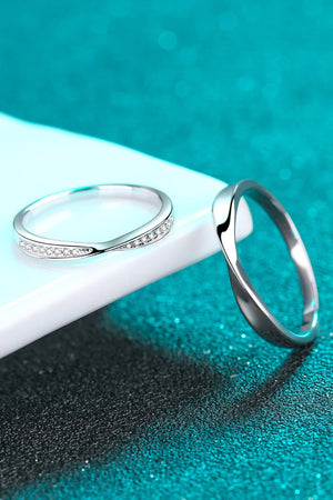 Silver band rings, one with pave crystals, on a textured teal background